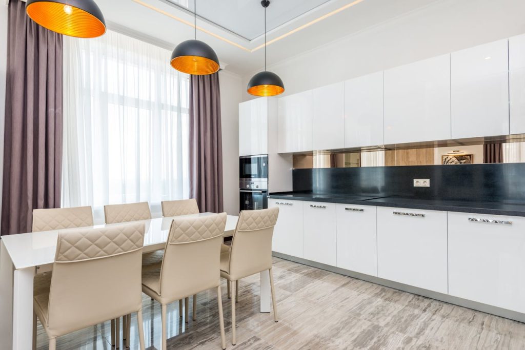 Bright contemporary kitchen with sleek white cabinetry and stylish dining setup.